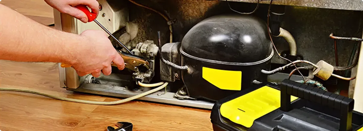 Refrigerator repair technician fixing the compressor and wiring in Paradise Valley, AZ