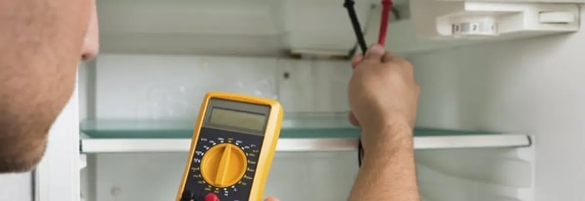 Refrigerator repair technician testing electrical components with a multimeter in Phoenix, AZ