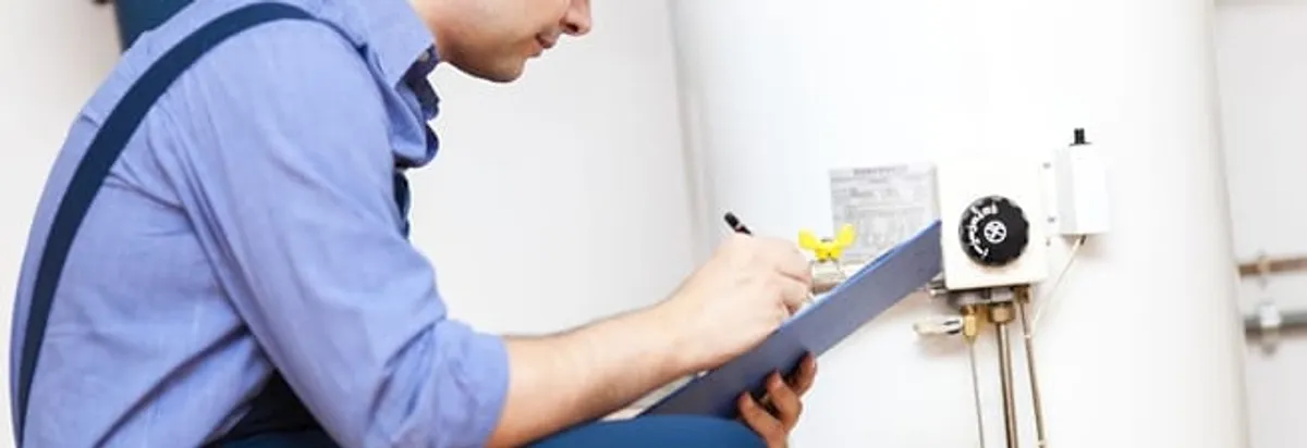 Water heater repair technician inspecting the unit and recording service notes in Phoenix, AZ
